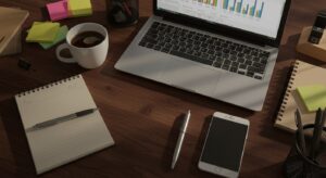 Top down view of entrepreneur’s workspace with laptop, coffee, phone, pixlelo.com Variation 59